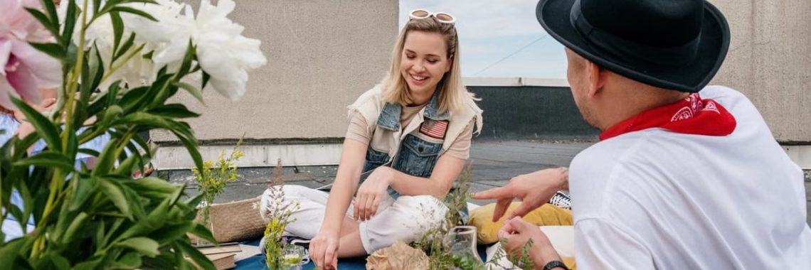A cheerful group of friends enjoying a summer picnic on a rooftop, capturing leisure and friendship outdoors.