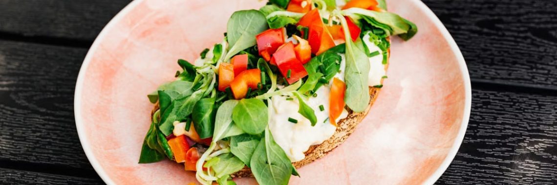 Delicious open-faced sandwich with fresh vegetables on whole grain bread, perfect for a healthy meal.